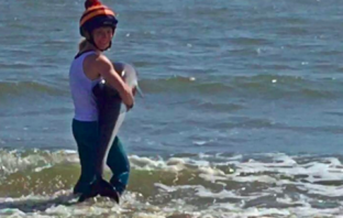 Woman Saves Baby Dolphin That Was Stranded on A Beach