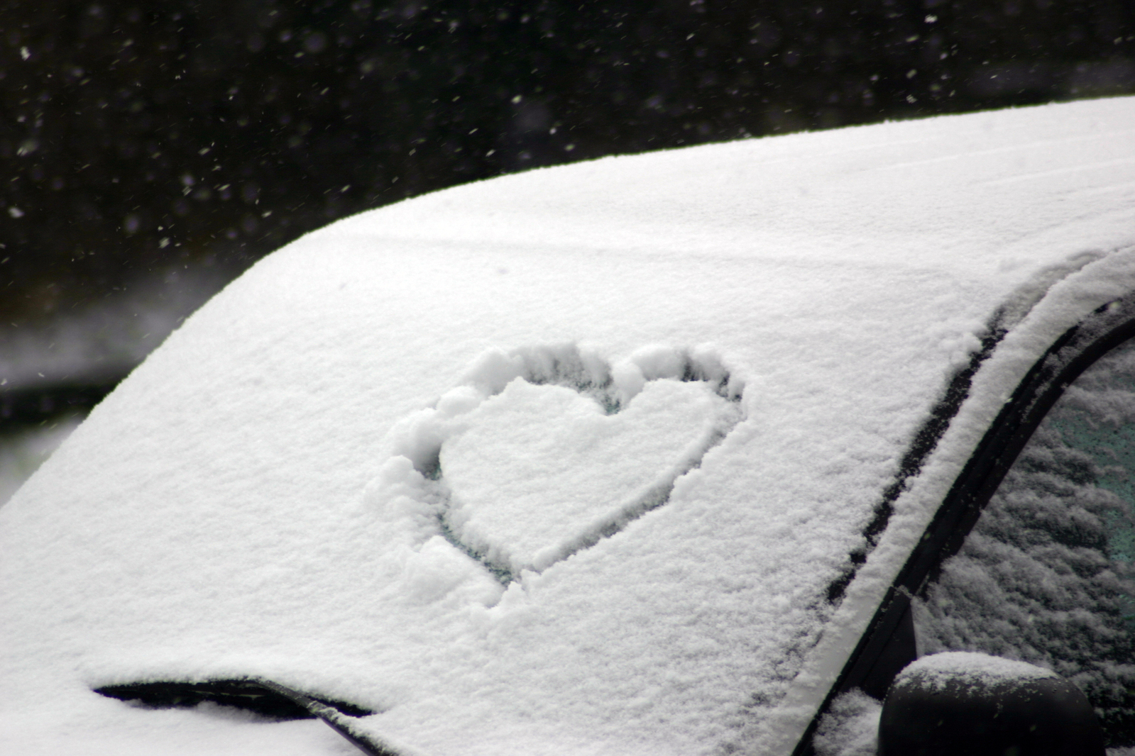 Сердце на стекле машины снег